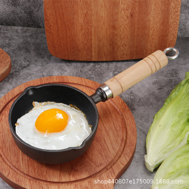 家庭用の熱い油をこぼして卵の小さい鉄の鍋を焼きます。|undefined