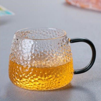 ハンマーのガラスのコップはお茶を入れるコップを持っています。|undefined