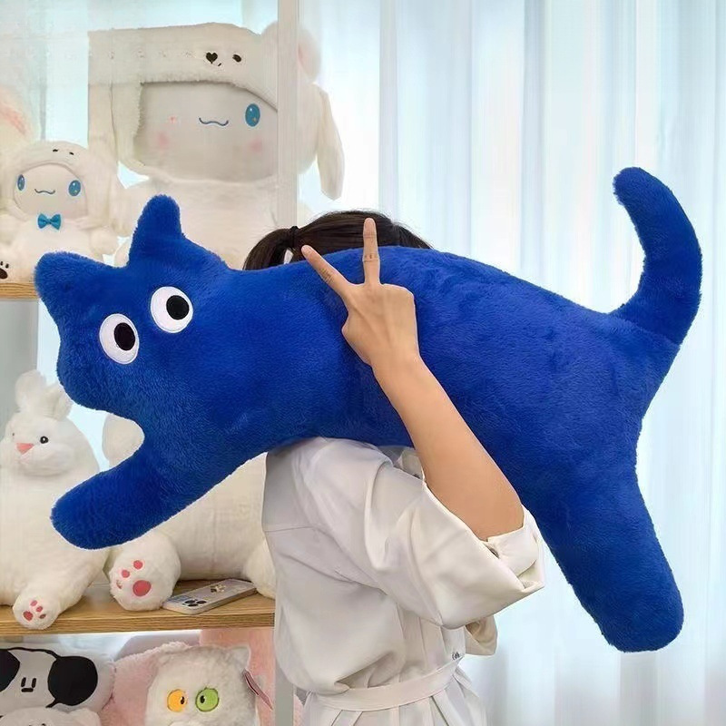 猫の長いドーパミンのぬいぐるみは足のソファーのクッションを挟んでいます。|undefined