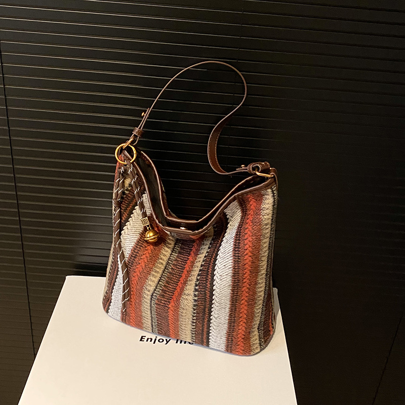 Bolsa de cubo de tendencia coreana a rayas, bolsa de hombro de gran capacidad, otoño y invierno 2025, nueva bolsa de mochila casual para mujeres.