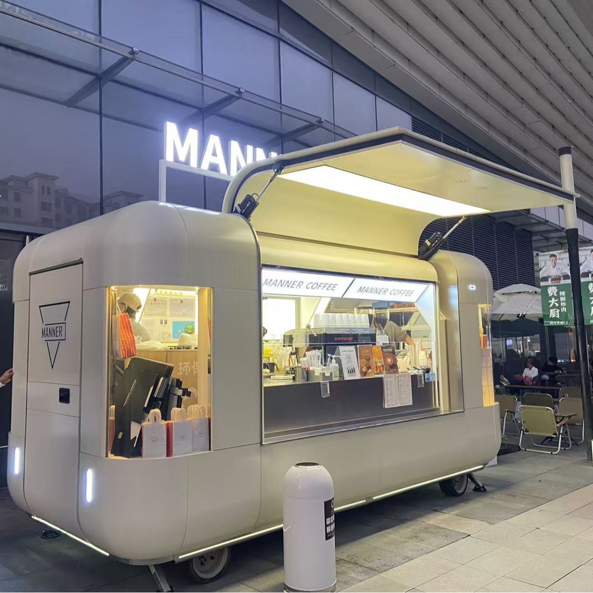 Carritos de comida comerciales en zonas turísticas, modernos food trucks, puestos en zonas turísticas que ofrecen té con leche y barbacoa.