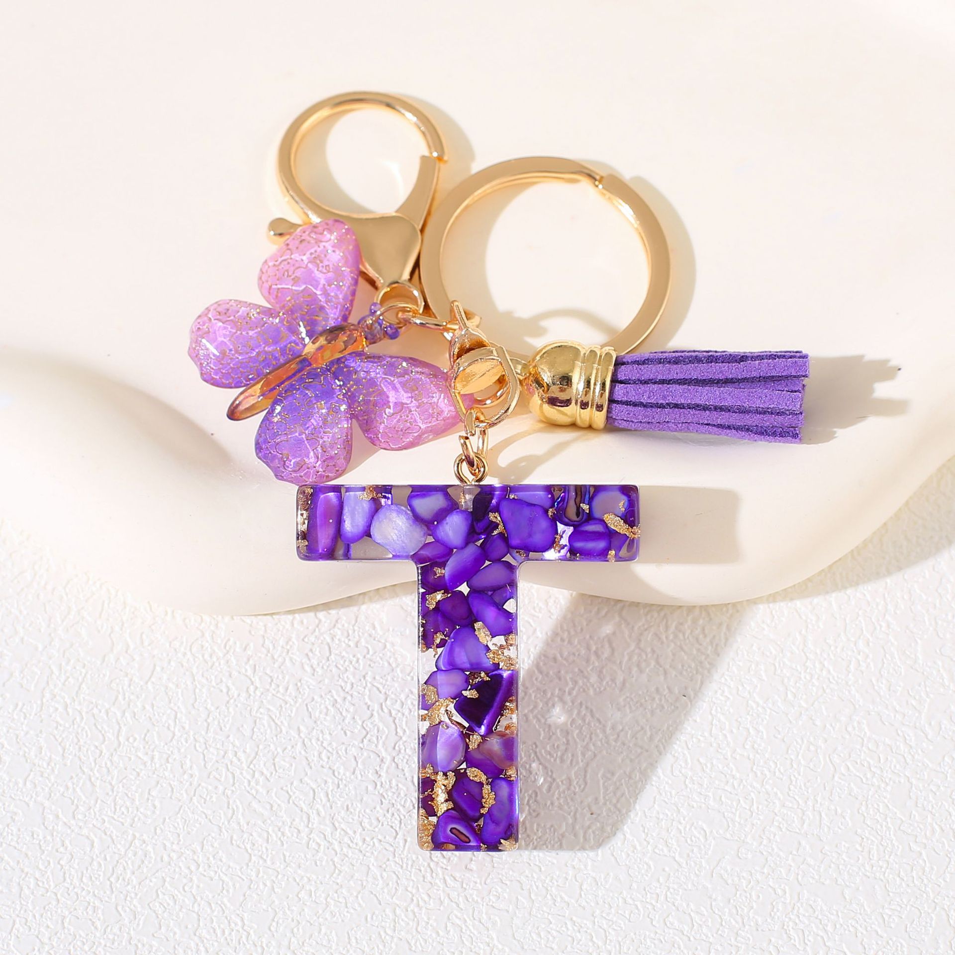 Fábrica directa de Yiwu accesorios de resina de goteo de embalaje llavero anillo de metal letras mariposa brilla colgante damas