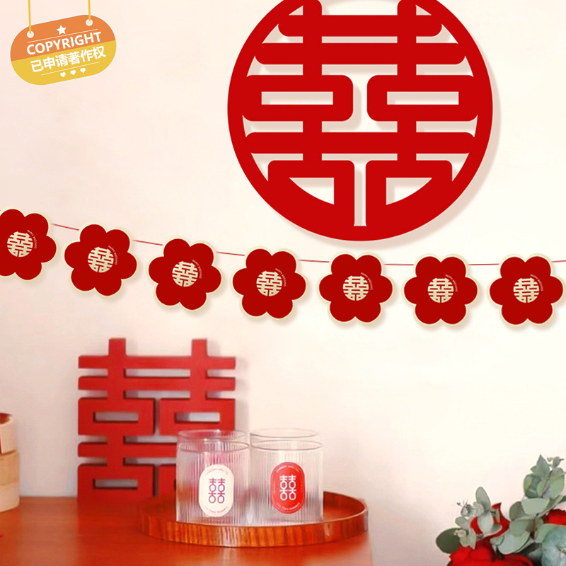 Marriage room decoration with flowers, large double happiness, garlands, festive red banners, decorative items, and hanging ornaments.