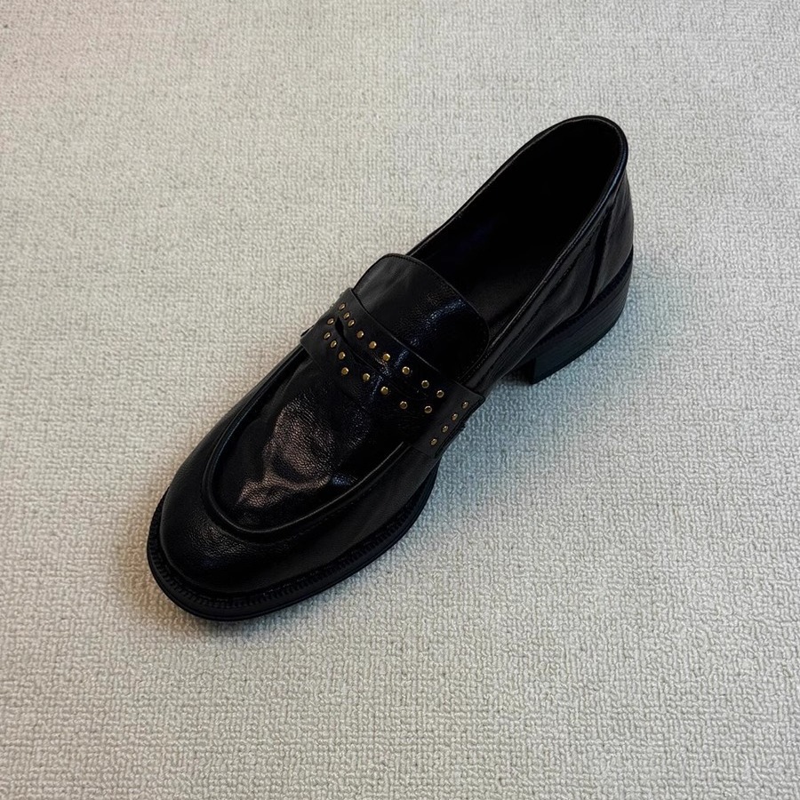Versión de cuero de vaca de cuero retro estilo británico Remache de cabeza redonda plisado con un pie pedaleando zapatos de cuero negro gruesos zapatos de cuero para mujeres