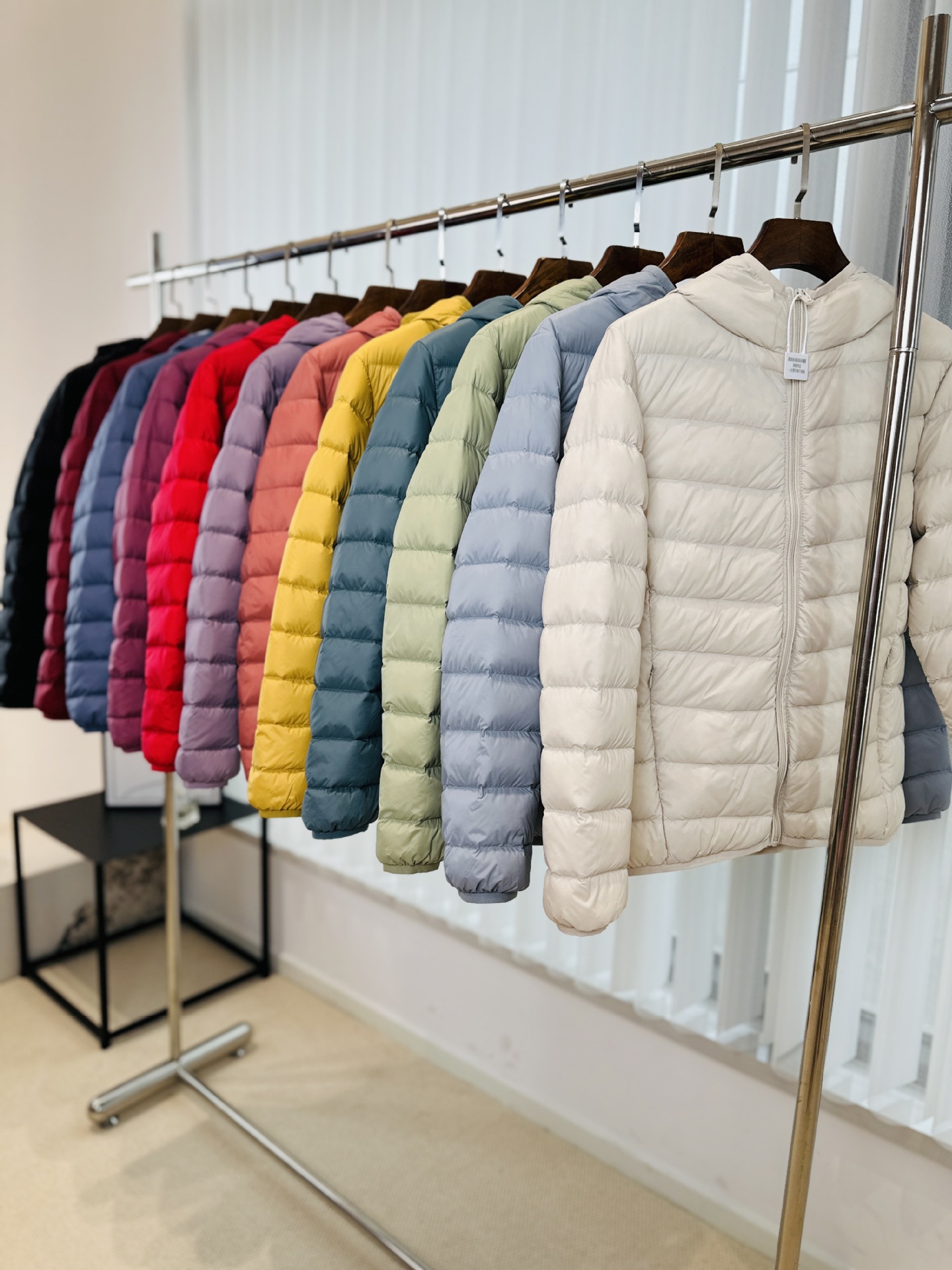 Chaqueta de plumón ligera para mujeres otoño y invierno 2025 nueva chaqueta de plumón de costillas con capuchón corto conveniente para almacenar chaqueta pequeña
