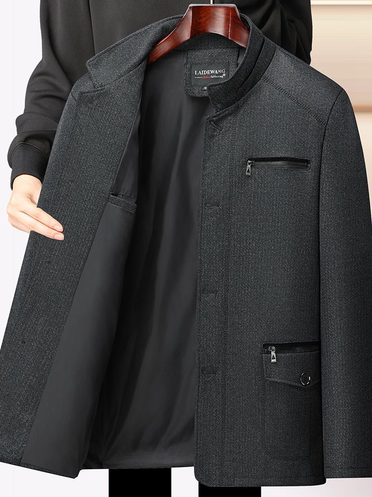 秋冬の中高年のメンズとベルベットのコートのお父さんはビジネス服の中年の男性の厚いジャケットの上着を襟を返します。