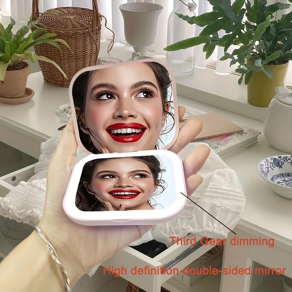 Venta directa de fábrica Espejo de maquillaje Regalo portátil Espejo de maquillaje de mano plegable con luz de carga Modelo avanzado transfronterizo