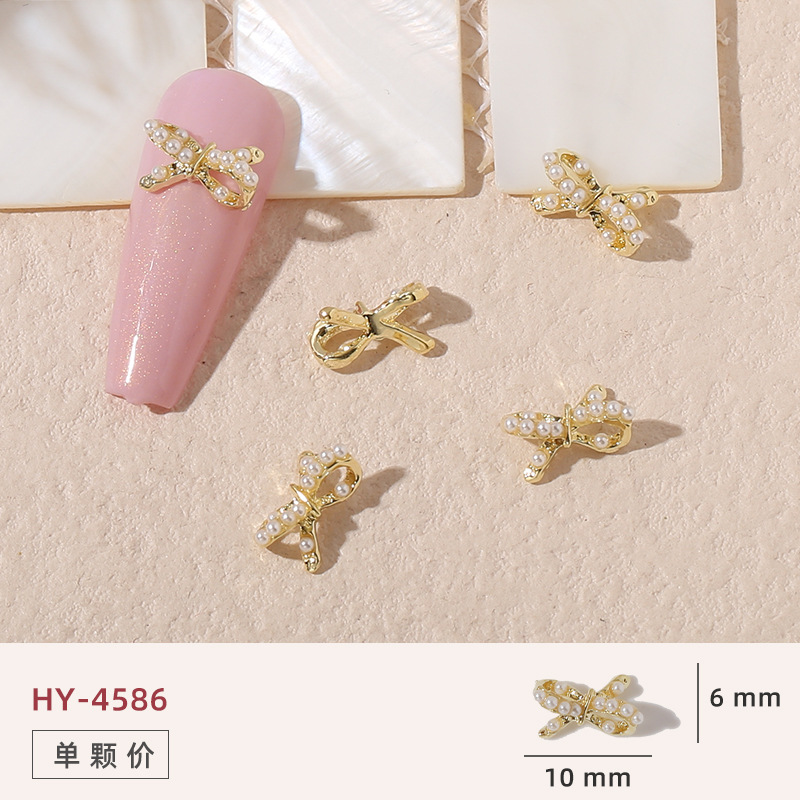 Uñas mariposa joyería nueva línea popular perla arco metal decoración de uñas pequeños accesorios de joyería al por mayor