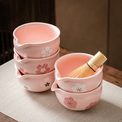 国境を越えて陶磁器の抹茶茶碗に口の花型の図案のお茶を提供します。