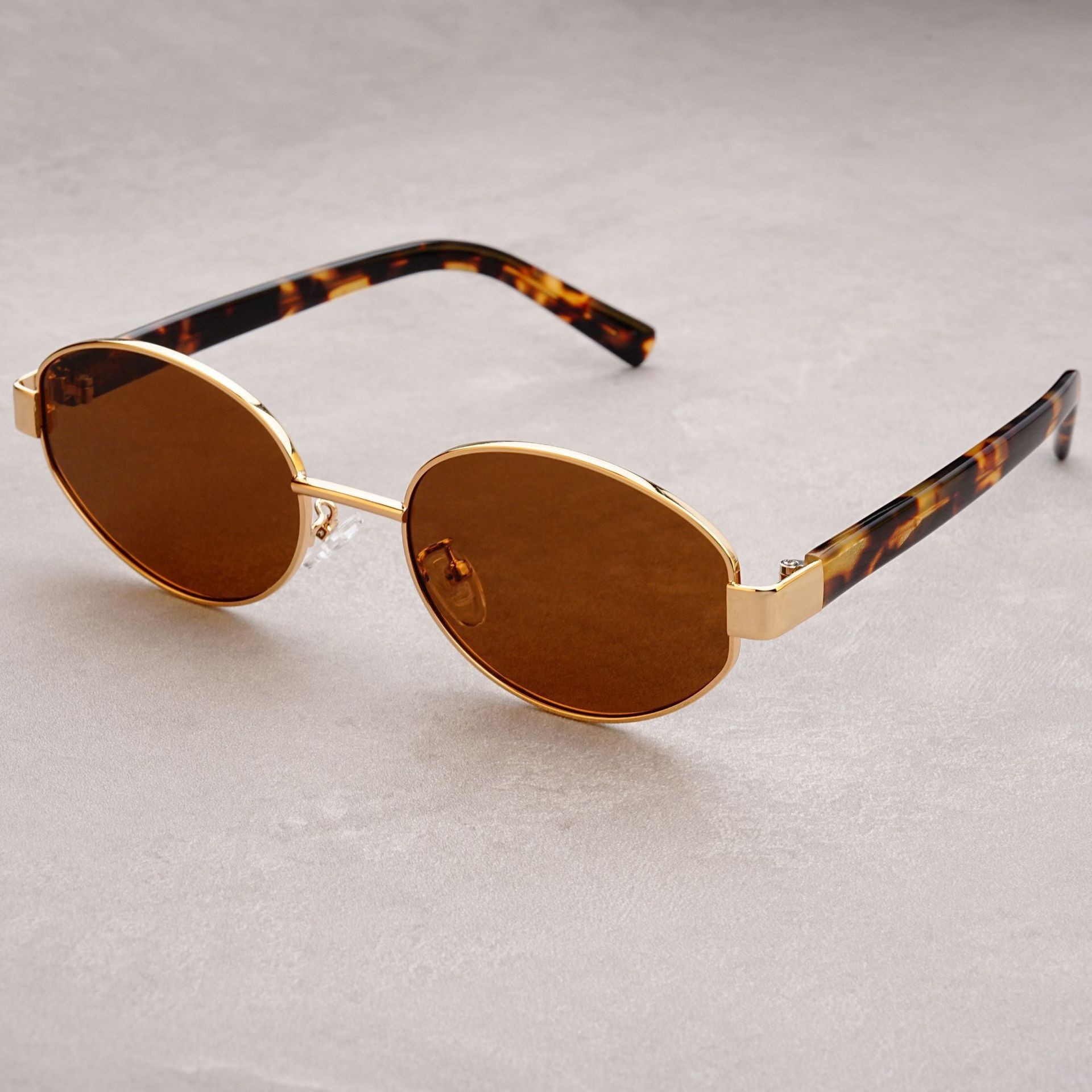 Vintage-Sonnenbrille im Retro-Stil mit strukturierter Oberfläche, dicken, ovalen, polarisierten Gläsern und UV-Schutz durch Acetat-Einsätze an den Bügeln._voghion.com