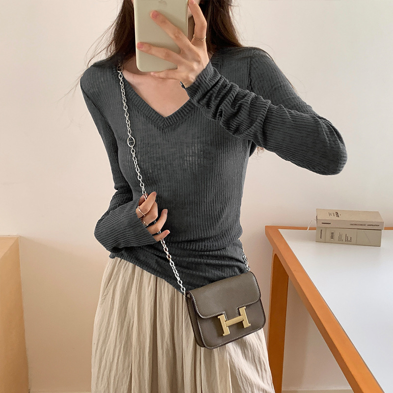 スリムギャルの薄いタイプの長袖のニットの女性の早秋の新型のデザイン感のvネックのtシャツを重ねて上着を着ます。|undefined