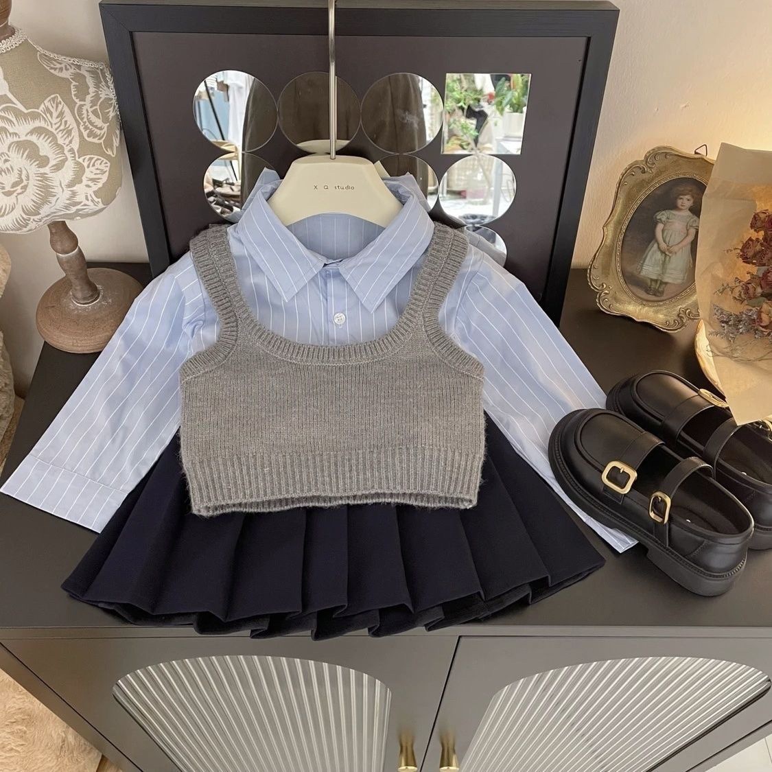 Conjunto de tres piezas estilo coreano para niña, otoño 2026: chaleco, camisa azul a rayas y falda plisada, estilo preppy.