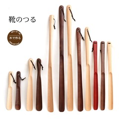 木の実木の靴の抜子の長い柄の家庭は靴の器を持ちます。