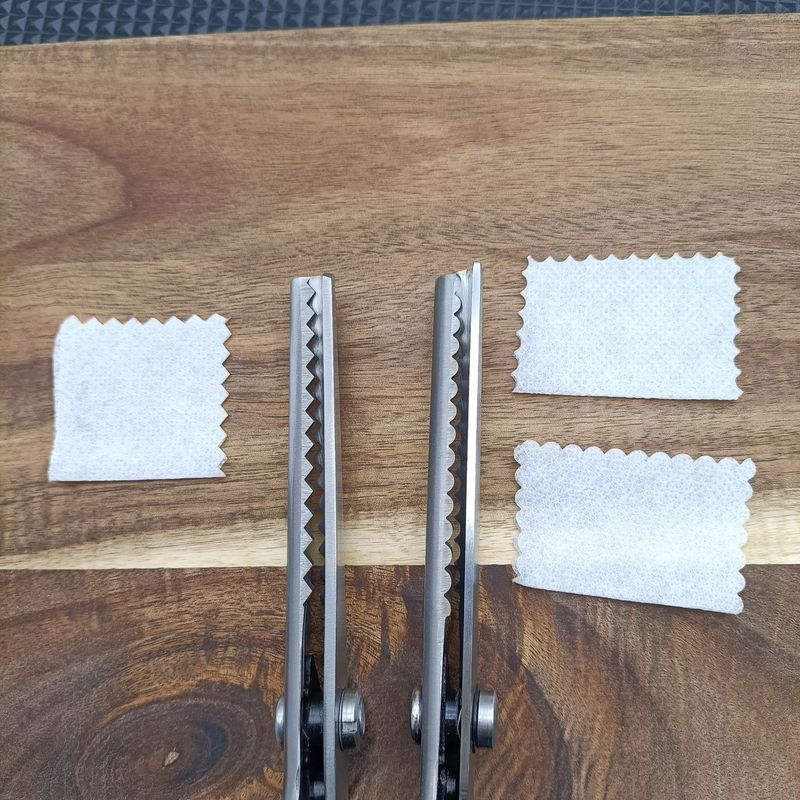 縁のない三角形の縁を切って裁縫専用の布を切ってDIY手作りの家庭用のこぎり型レースのはさみを切ります。|undefined