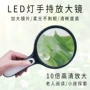 老人手持学生阅读放大镜