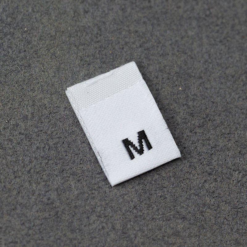 En stock Etiqueta de tamaño de alta densidad en blanco y negro Etiqueta de tamaño universal Etiqueta de código de letra inglesa Pantalones Etiqueta de código de cuello de camiseta