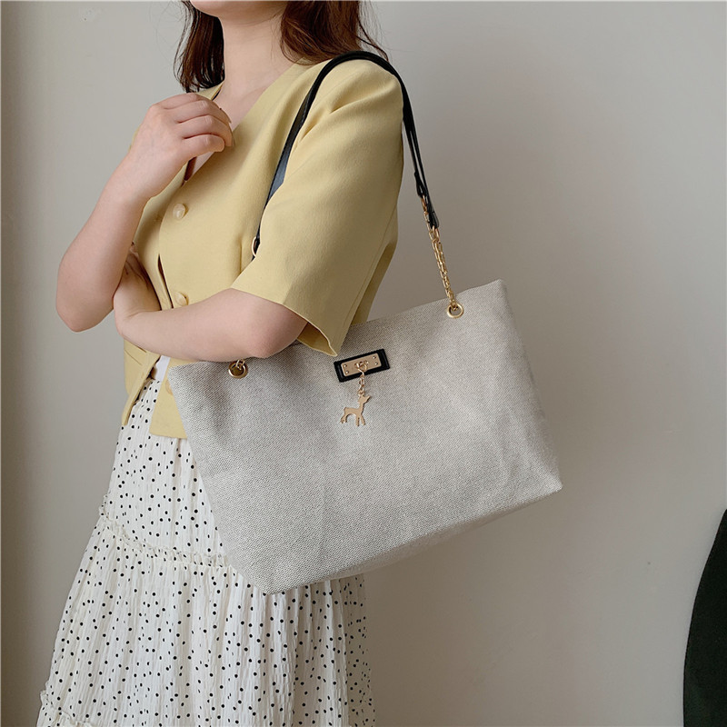 Textura simple, bolso de hombro versátil 2024 nueva moda moda de gran capacidad, bolso de transporte ligero, bolso de brazo