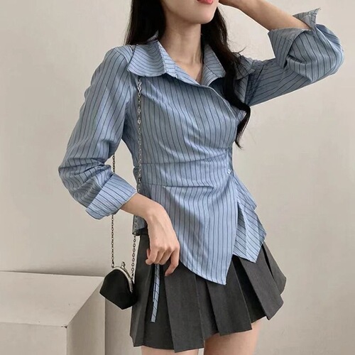 A stylish women's new spring collared shirt with a design featuring irregular cinched waist for a slimming effect, striped long sleeves, and a trendy vibe.