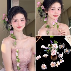 森系の花はピンクの新婦の頭飾りを挟みます。