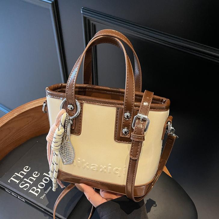 Retro brillante bolso de cubo de mano 2025 nuevo estilo bolso de hombro de color contrastante sensación de alto nivel bolso de mochila casual simple