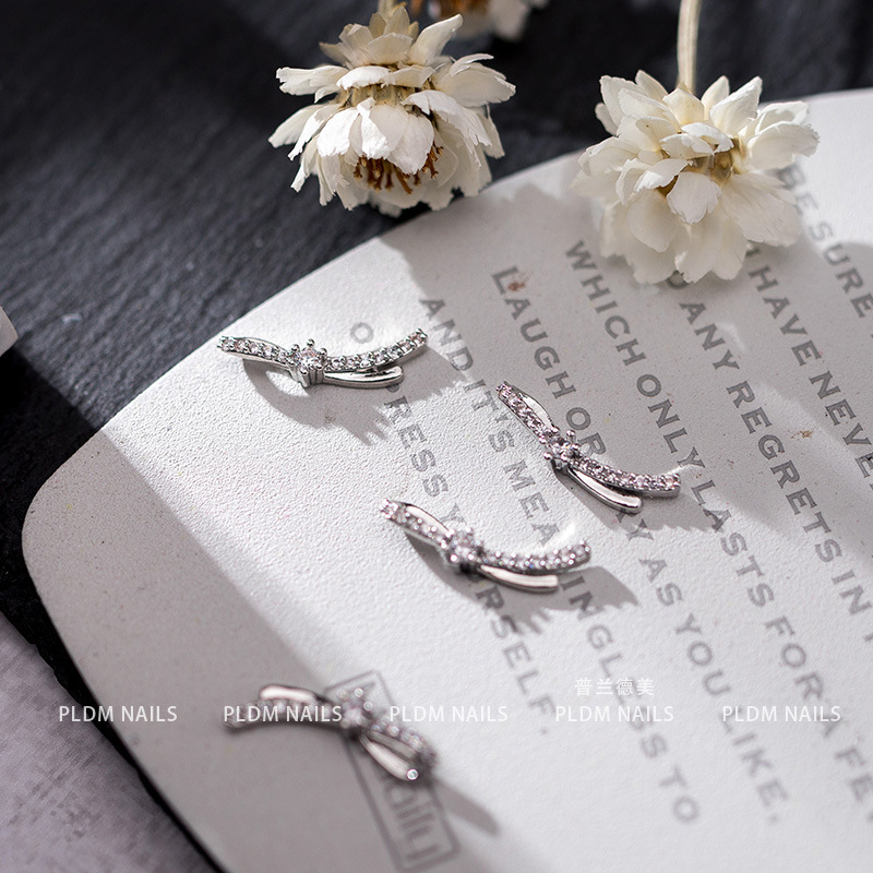 Accesorios de uñas de lujo ligero de alto grado con diamantes populares Tridimensional de la celebridad en línea de la joyería del arco de la cinta chapada en oro de la manicura