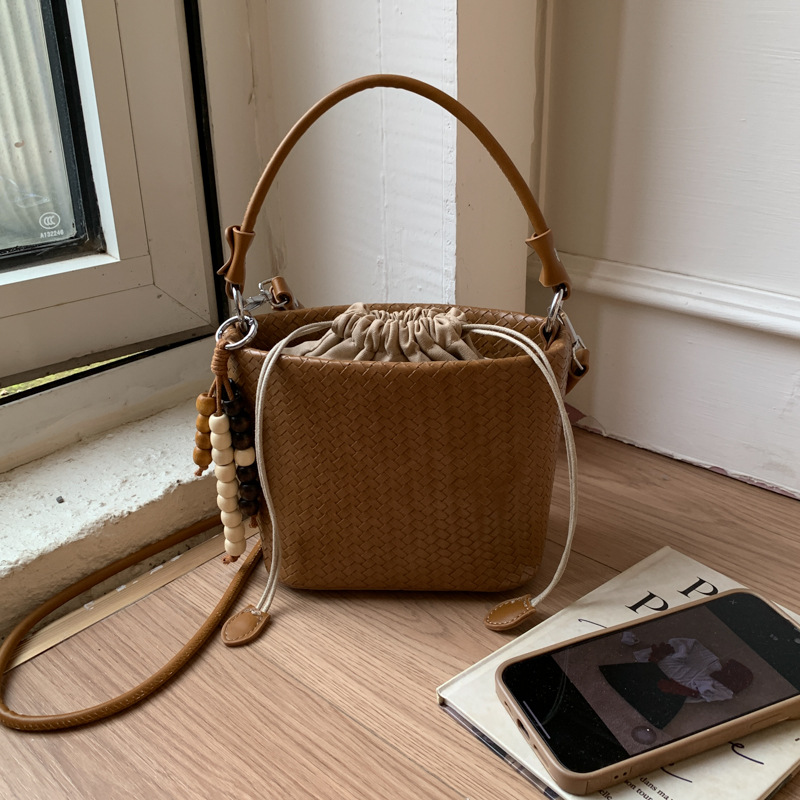 Transfronterizos bolsos de cubo de cuerda bolsos de mujer versátiles bolsos de mano otoño e invierno 2025 nuevo tejido mochila de viaje