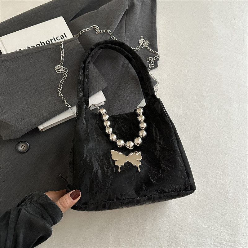 Alta sensación de lujo ligero bolso de cubo axilar 2024 verano nuevo estilo de moda arco de cuentas cadena de hombro mochila