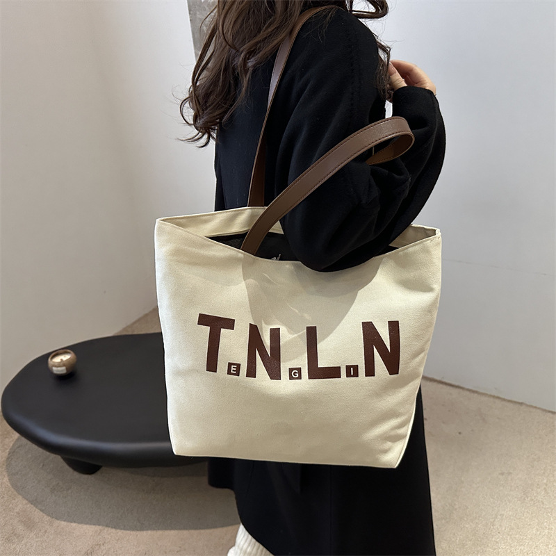Bolsa de lona de gran capacidad para mujeres otoño / invierno 2024 nuevo estilo coreano letras impresión bolso especial de nicho de viaje bolso de hombro