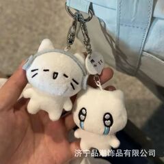 赤い本の同じタイプのかわいいアニメのイヤホンの猫のぬいぐるみのぬいぐるみのペンダントのキーホルダーは癒しのカバンを掛けます。