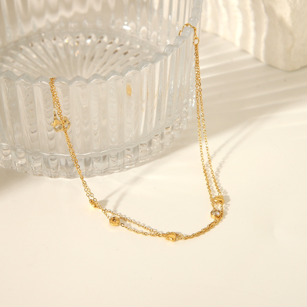 Estilo francés acero de titanio horno de 18K galvanoplastia de oro real doble amor circón tobillera verano femenino todo fósforo joyería de playa