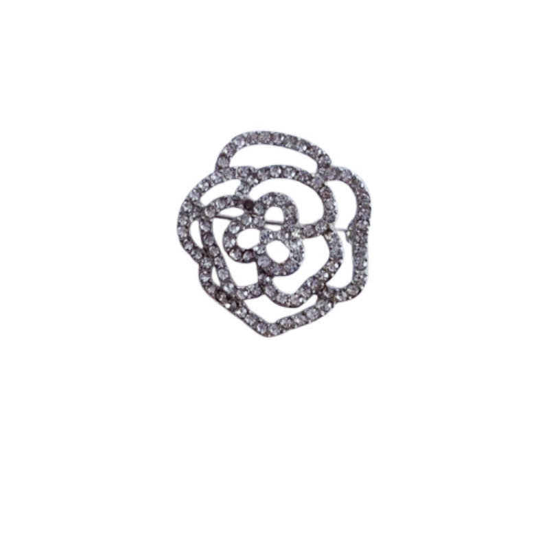 Elegant kameliabrosch med hålmönstrad rosdesign för rockar_voghion.com