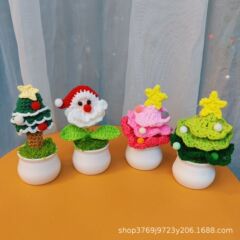 新しい国境を越えた手作りクリスマスツリーの小さな鉢植えのテーブルに毛糸を飾ってクリスマスのプレゼントを編む