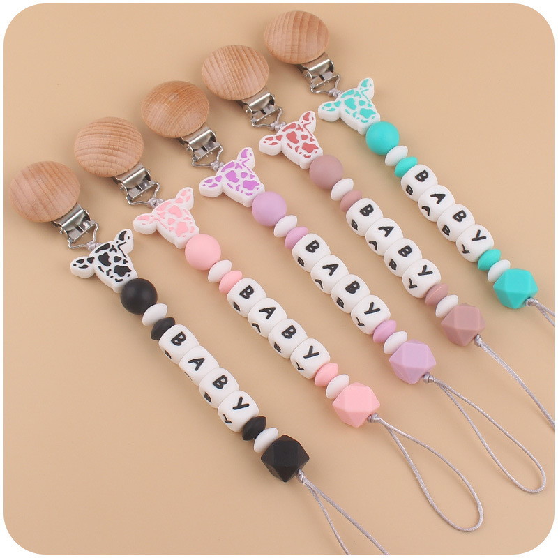 Nuevo bebé suministros de dibujos animados de silicona vaca cabeza mordedor creativo bebé DIY nombre mordedura pezón cadena anti-caída
