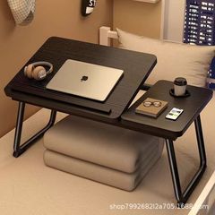 昇降は折り畳み式のベッドの上の小さいテーブルの寮で勉強します。