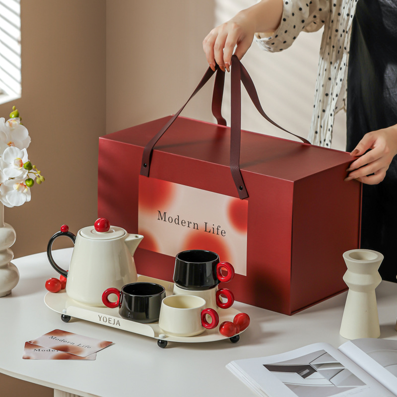La ama de casa moderna es la misma creativa encantadora de alto valor de la cara con un conjunto de utensilios de agua de cerámica doméstica para invitados con un conjunto completo de tetera de té