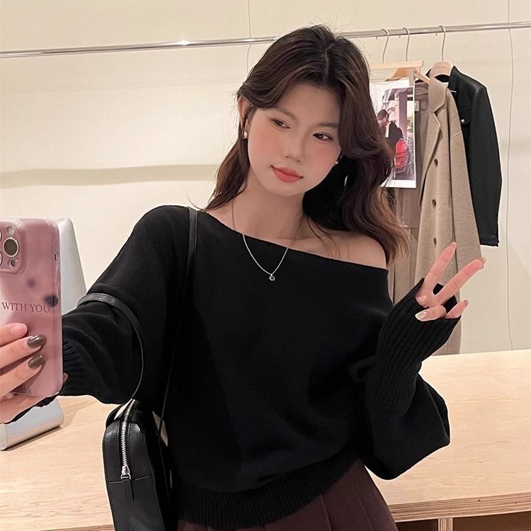 柔らかいピンクの不規則な長袖の斜めの肩のセーターの女性の秋冬の新型の修身の美しい露肩のchiのニットの上着