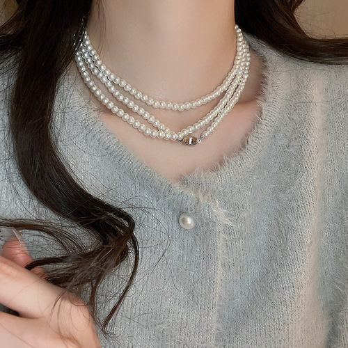 A high-end, diamond-embellished floral geometric pearl necklace with a light luxury vibe, sweater chain, French retro pendant accessory for autumn and winter.