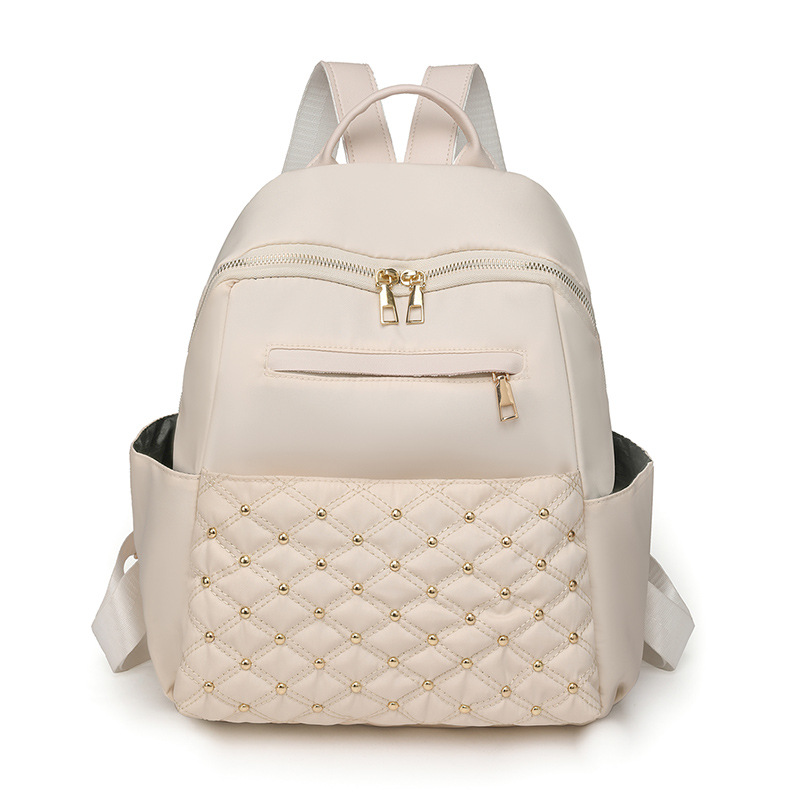 2023 nueva mochila de nailon para mujer coreana, remache de diamantes de moda, mochila de viaje de cercanías de gran capacidad al por mayor