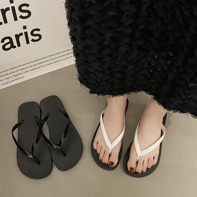 Шлепанцы девушки носят летние пляжные туфли на пляже