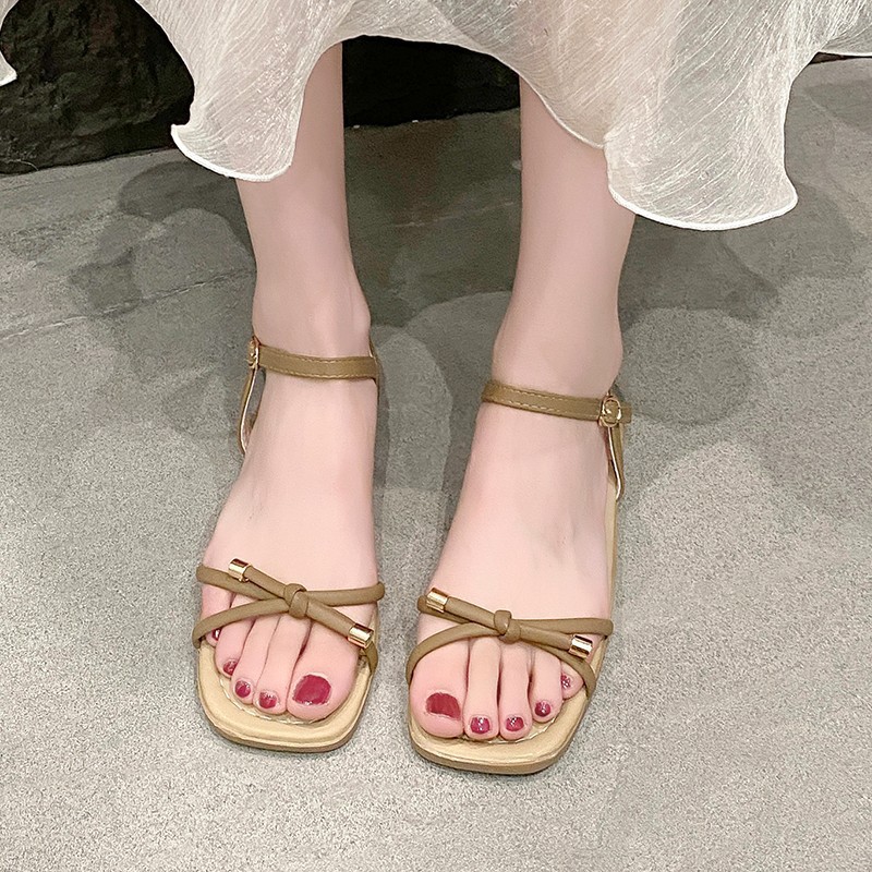 Arco sandalias planas para mujeres verano 2026 nuevo estilo con una sola línea suave de hadas estilo versátil no cansado zapatos de viaje