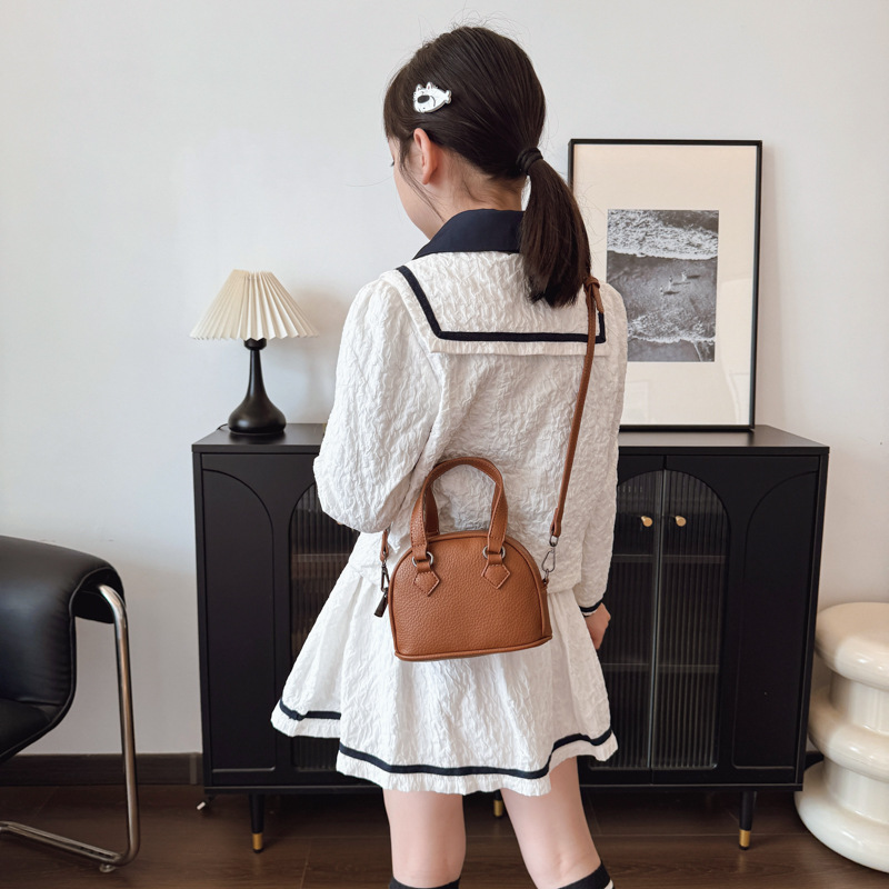 Moda coreana de color sólido bolso de hombro para hombres y mujeres, mini lindo bolso de concha de bebé 2025 nuevo bolso de mano para niños