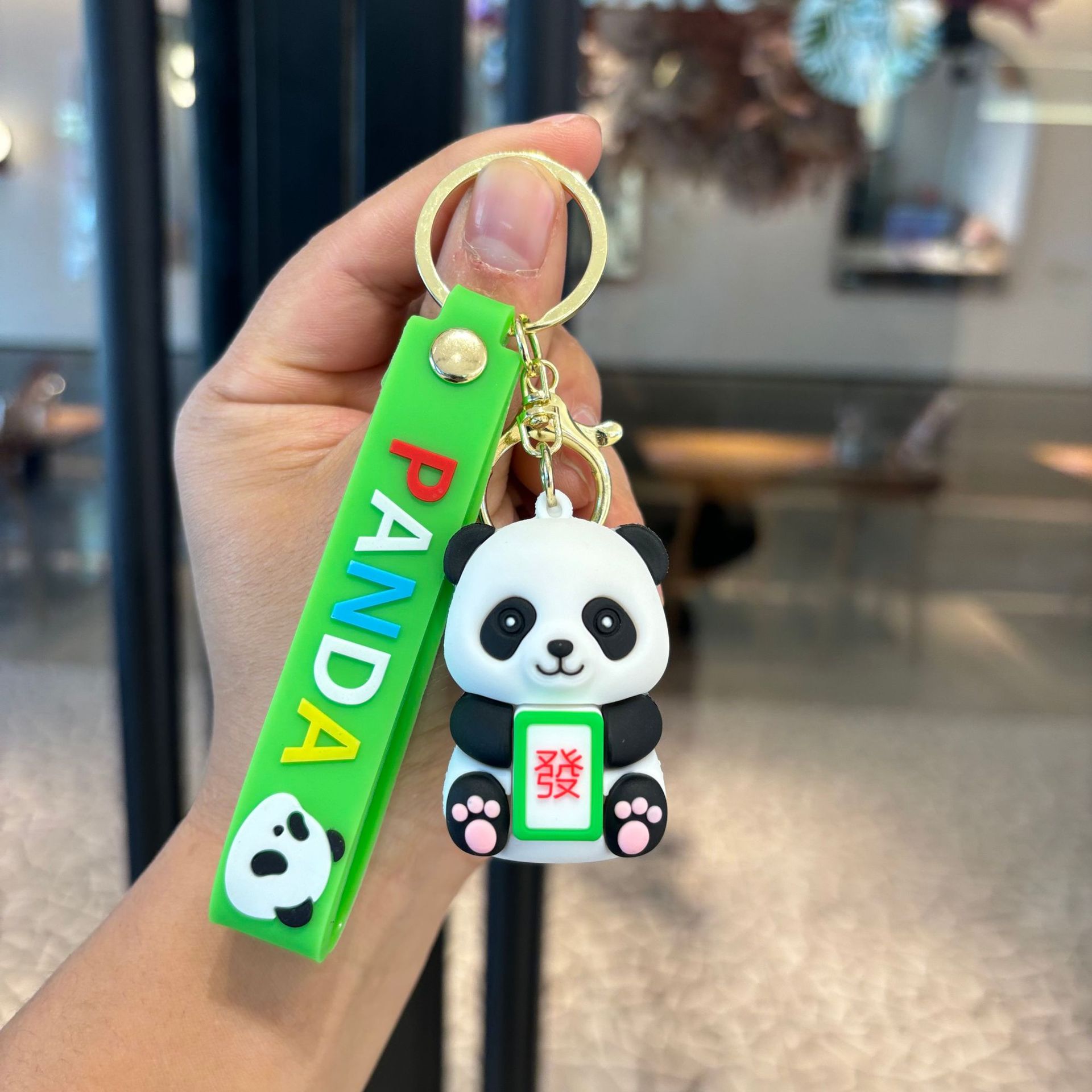 アニメは竹のパンダのキーホルダーを抱いてかわいいパンダのカップルの小銭入れを掛けます。