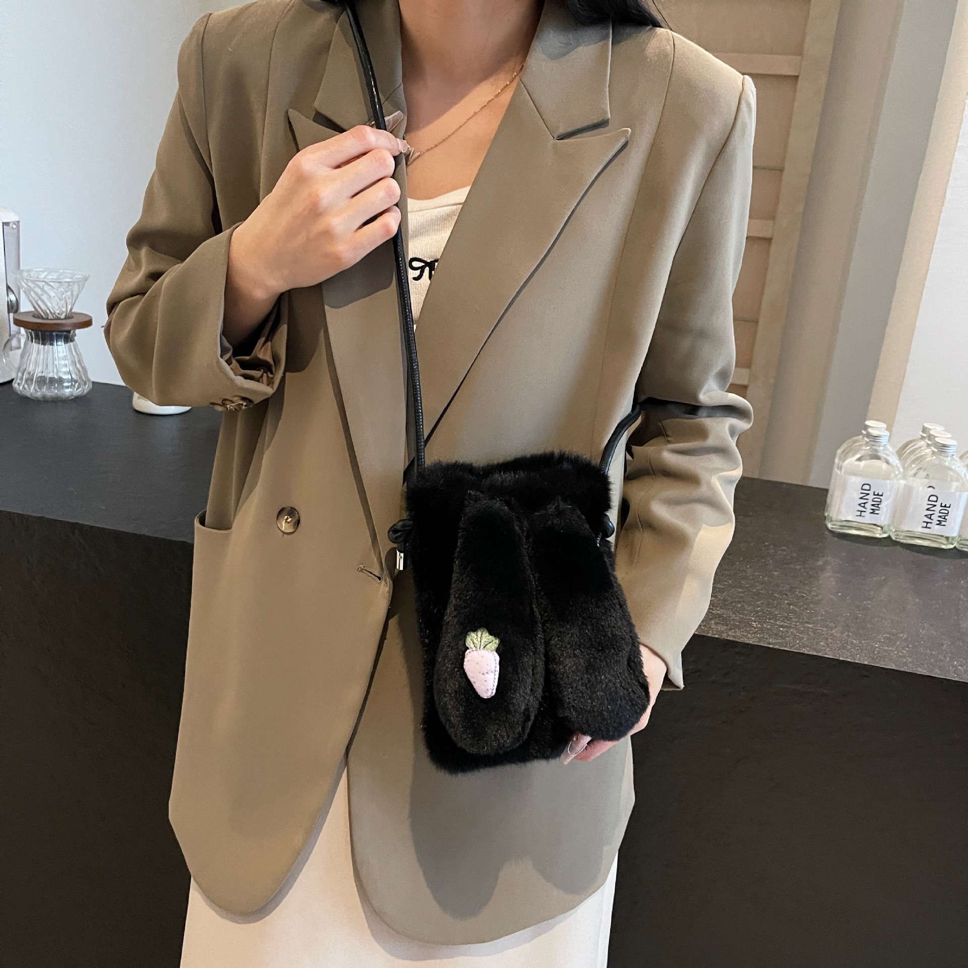 El bolso de teléfono móvil de nicho popular transfronterizo 2025 imita la moda del visón, con un bolso de pelo de oreja de conejo en un hombro.