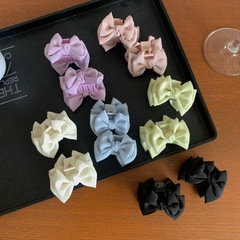 二つのクリーム色のサテンの蝶結びはお姫様の髪を挟んで、小さい前髪をつかみます。