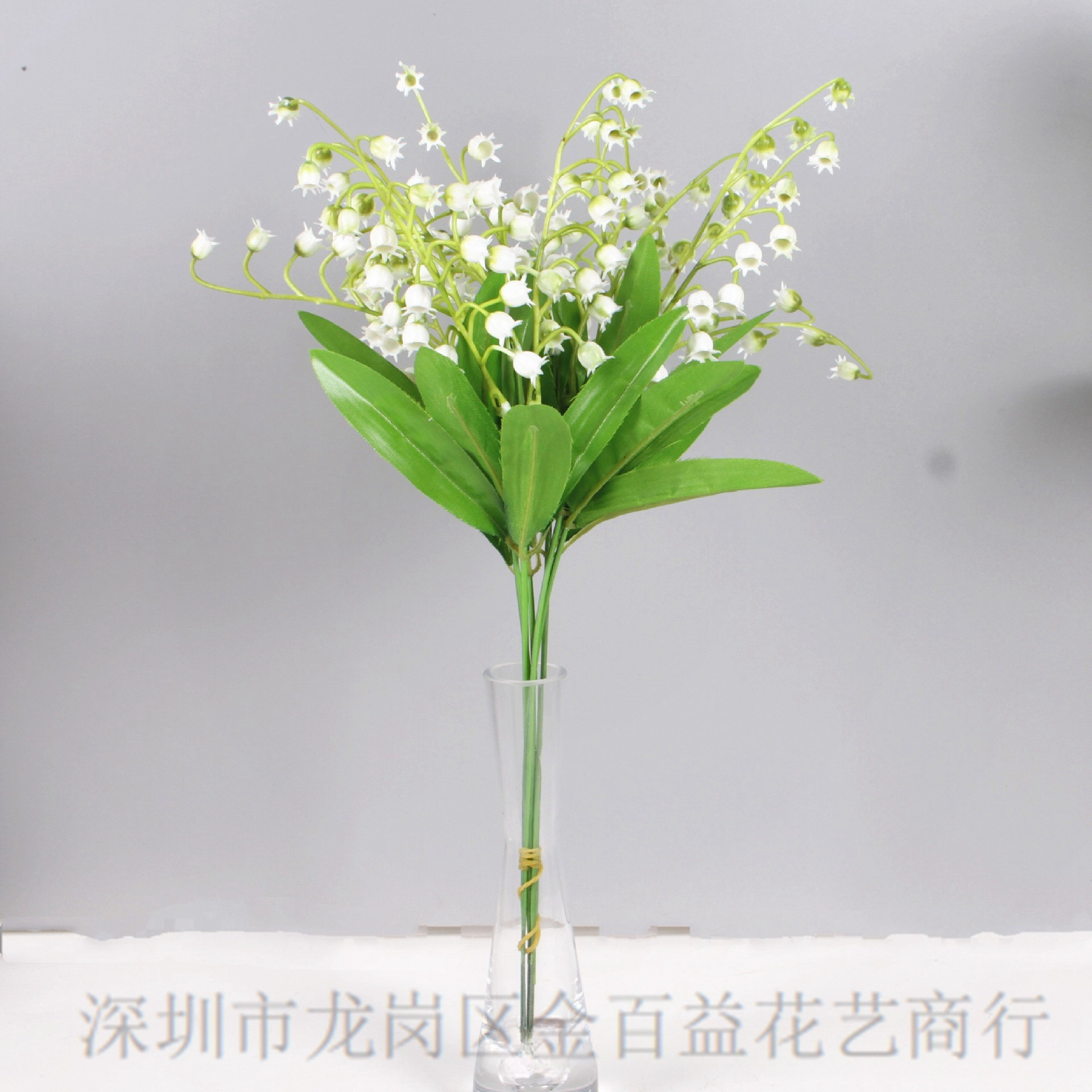 El viento del interior sostiene un ramo de lirio de los valles, flores artificiales frescas, flores de plástico blancas, mesa de comedor, flores falsas, flores decorativas, flores