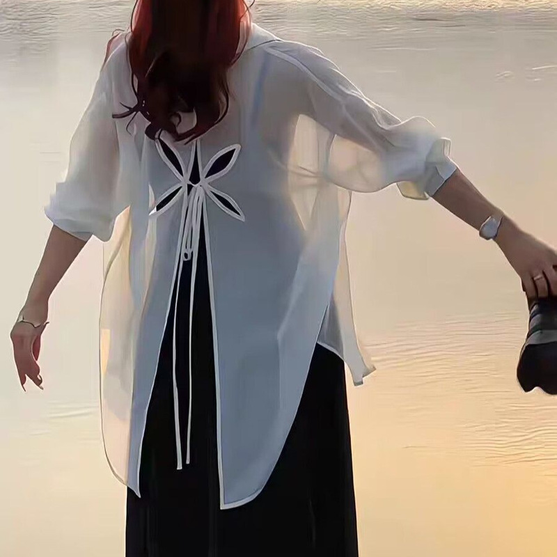 薄いタイプの微透長袖日焼け止めカーディガンの背中には、青いシャツ付きの女性夏のファッションカジュアルシャツのコートがあります。|undefined