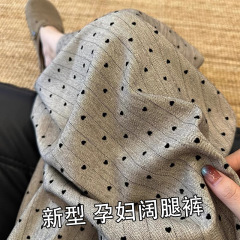 妊婦のカーキ色のポイントのズボンの女性は腹を支えて縄を引きます。