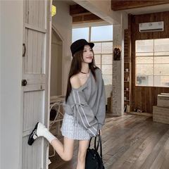 レースのストライプの蝶結びは肩を露出した長袖のパーカーの女性です。
