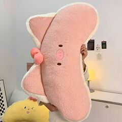 かわいいピンクの豚は枕の長いストリップを持って枕の女子学生を抱いて寝ます。