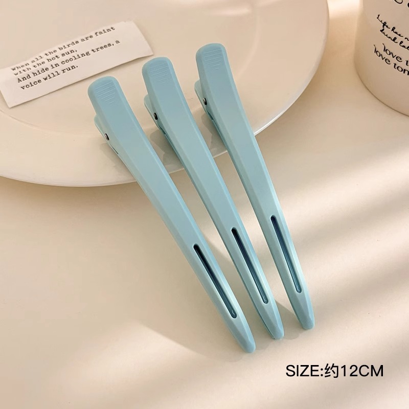 Clip de cabello sin marca especial para lavar la cara y maquillaje con clip de boca de pato posicionado en la parte lateral de la frente frente